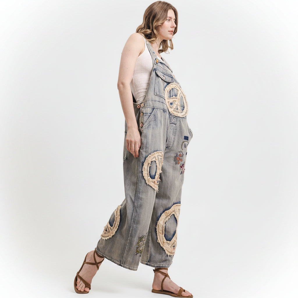 Woman wearing a Bluevelvet denim jumpsuit with peace symbol designs on a white background
