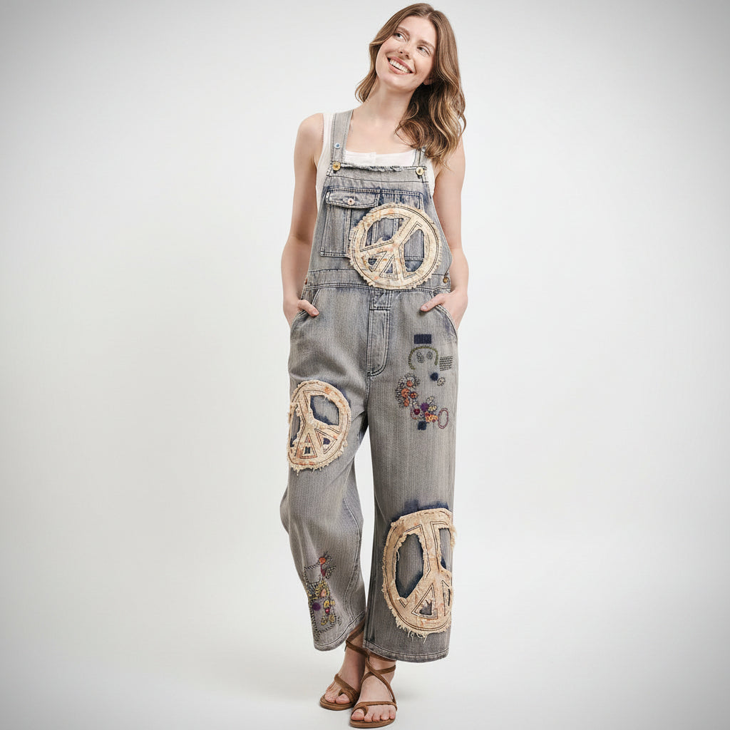 Person wearing Bluevelvet denim overalls with peace symbol patches on a plain background