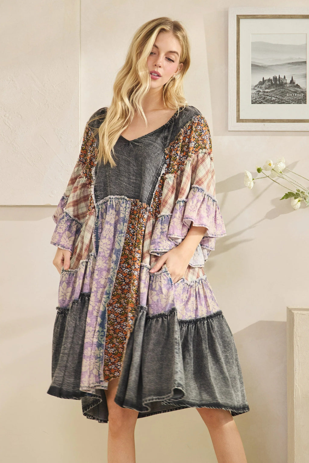 Woman wearing a patchwork dress with a neutral background