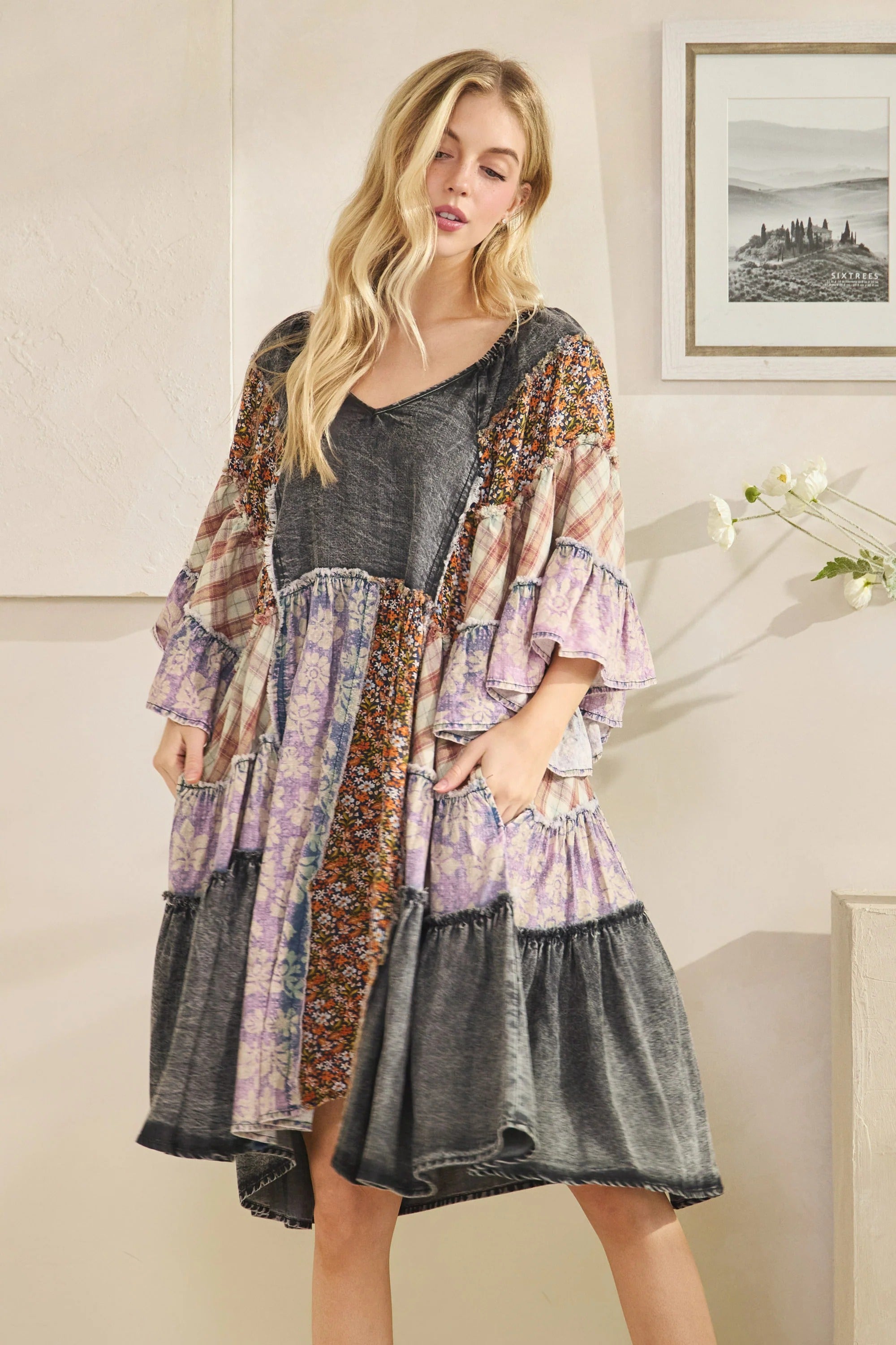 Woman wearing a patchwork dress with a neutral background