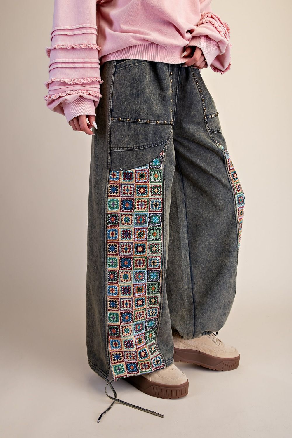 Easel Clothing dirty denim wide-leg pants, side view showing crochet jacquard patchwork panel detail on model
