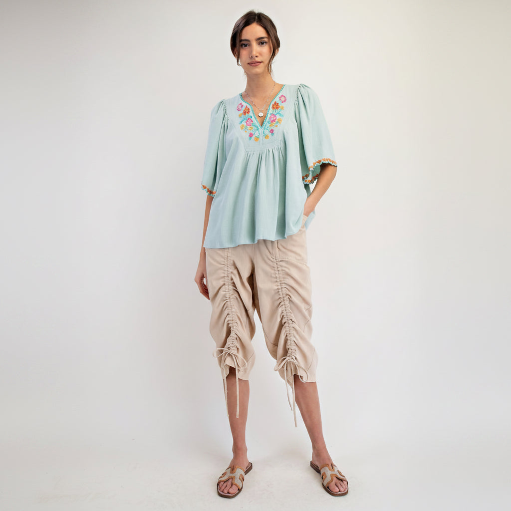 Easel khaki twill capri pants styled with embroidered mint blouse and tan sandals, full outfit view
