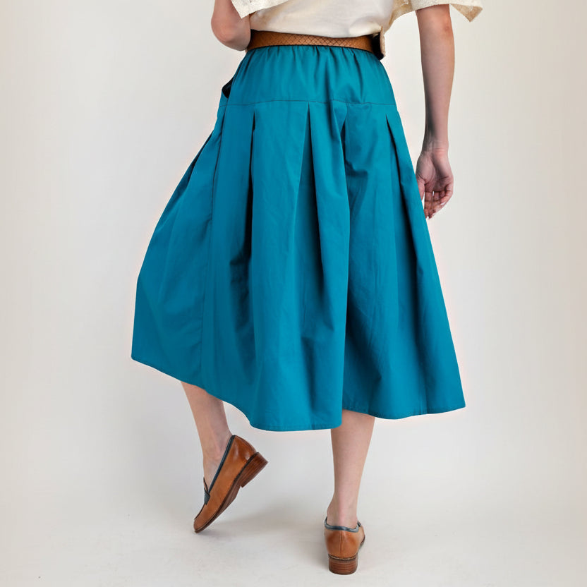 Easel teal pleated midi skirt back view showing back pleats and skirt movement
