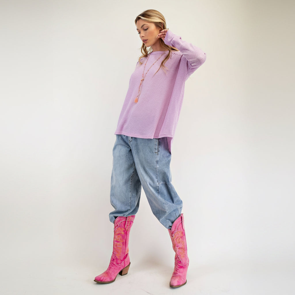Easel lavender pink relaxed pullover styled with wide leg jeans and pink cowboy boots, full outfit view
