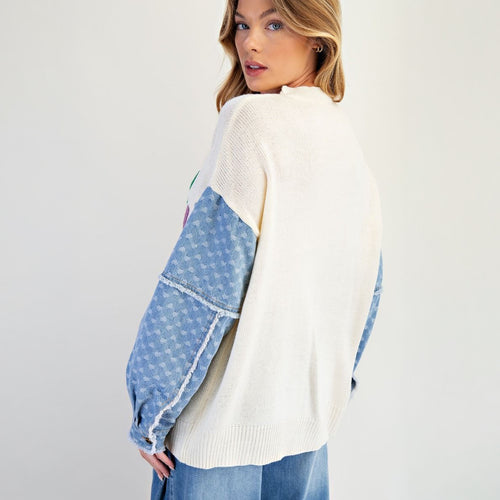 Lucky letter knit sweater in ivory, three-quarter view showing denim-style heart-print sleeves

