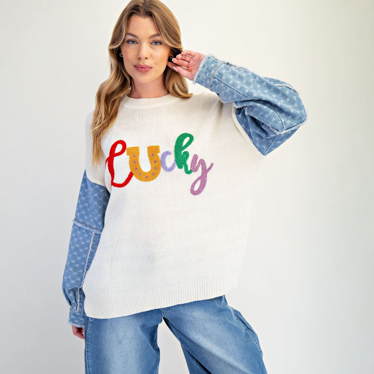 Ivory lucky letter sweater styled with denim, relaxed oversized silhouette, full-length view
