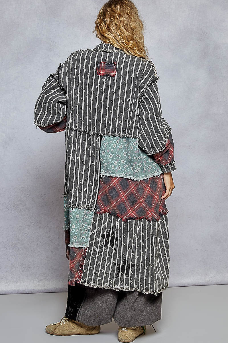 Person wearing a patchwork coat with a gray background