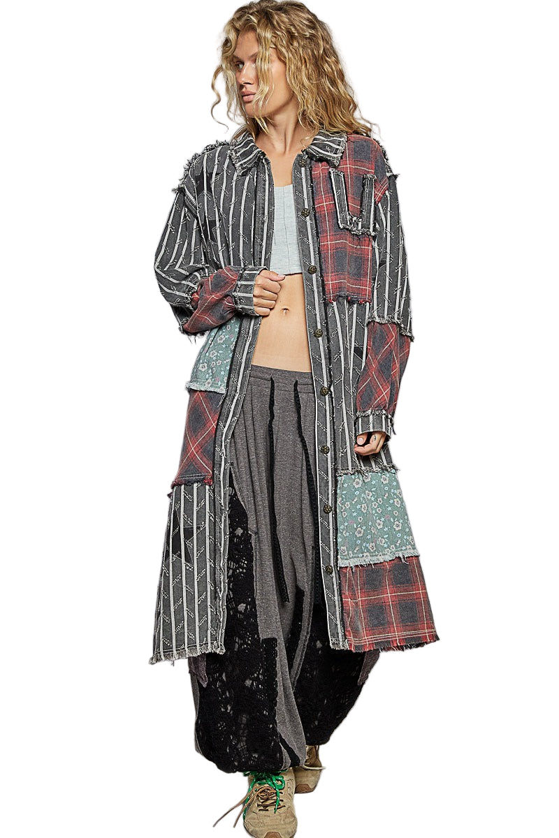 Person wearing a long, patchwork-style coat with a plaid pattern on a white background