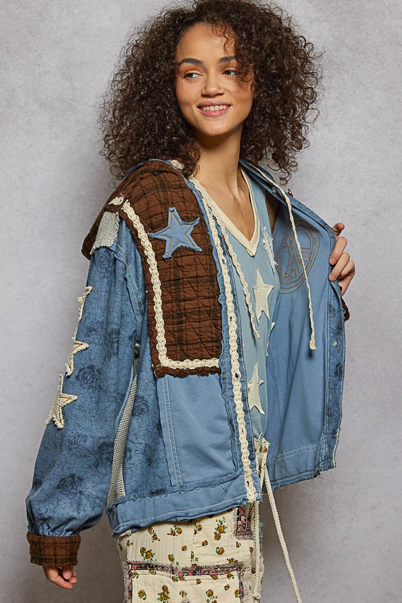 Woman wearing a denim jacket with star patterns on a gray background