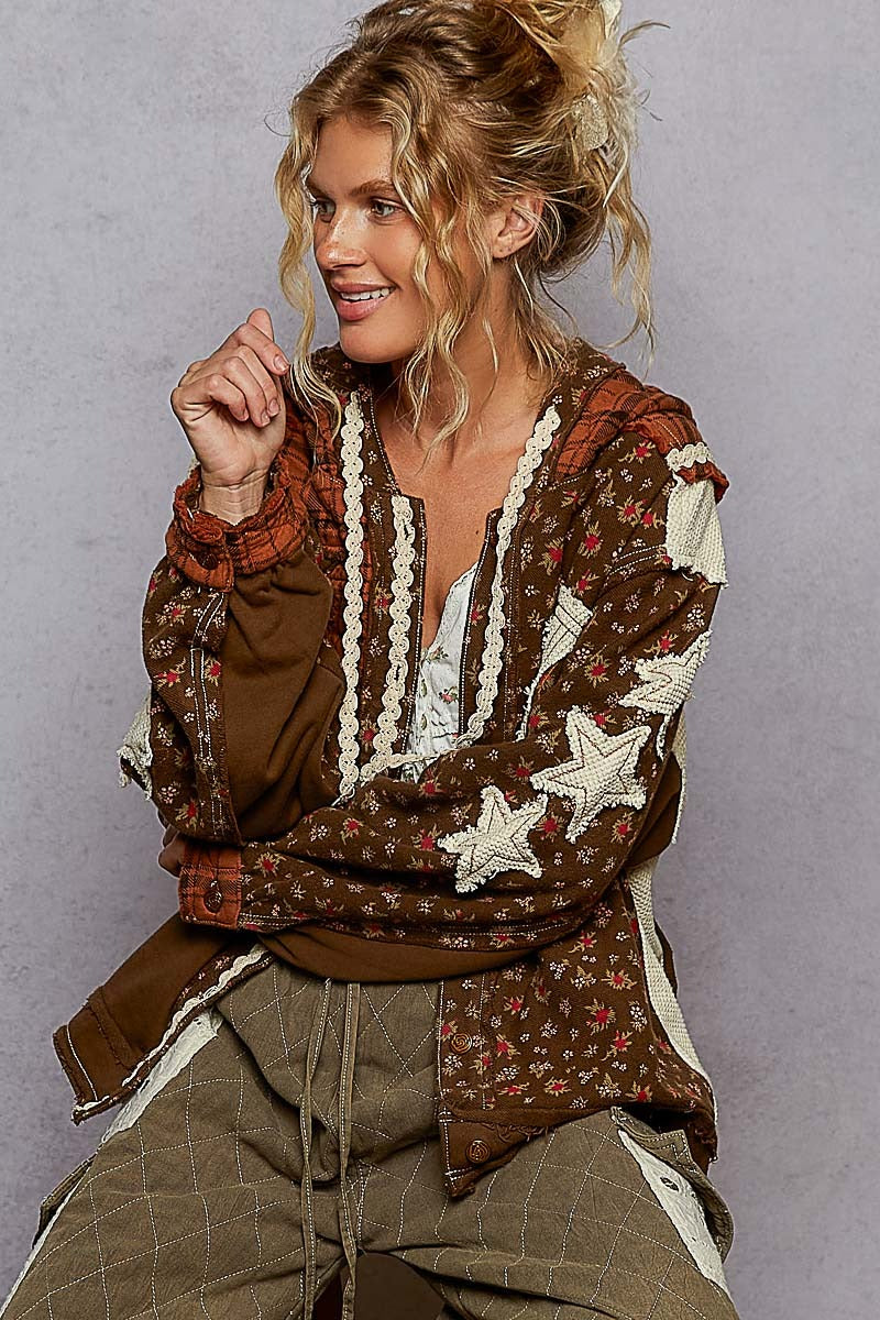 Woman wearing a patterned jacket with star designs on a plain background
