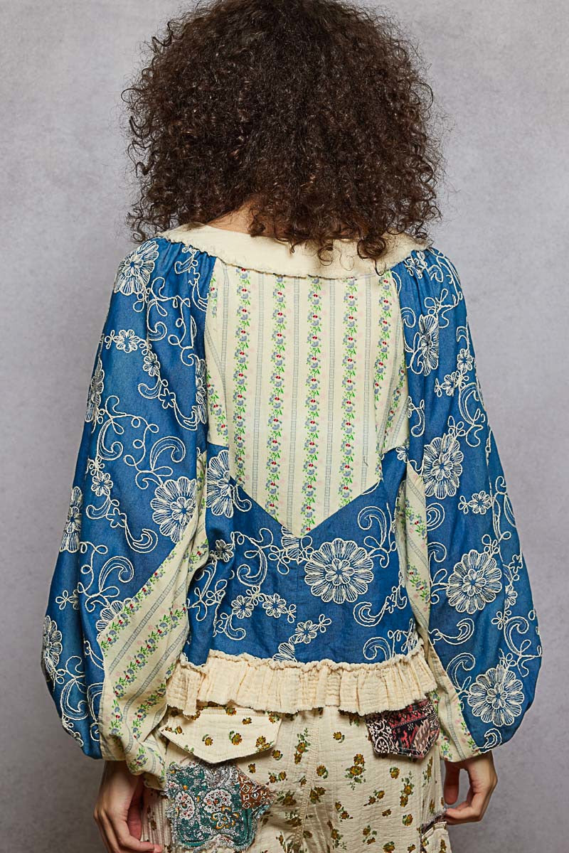 Person wearing a blue and white patterned top with a gray background