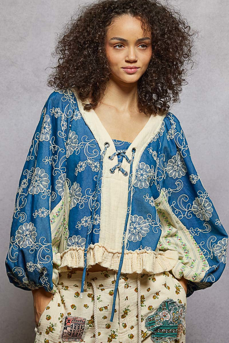 Woman wearing a blue floral patterned outfit with a gray background