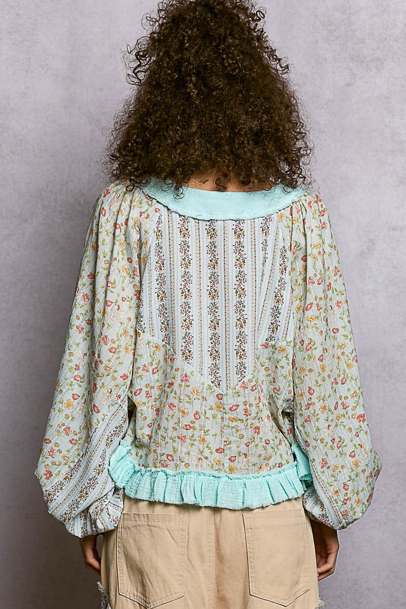 Person wearing a floral blouse with a plain background