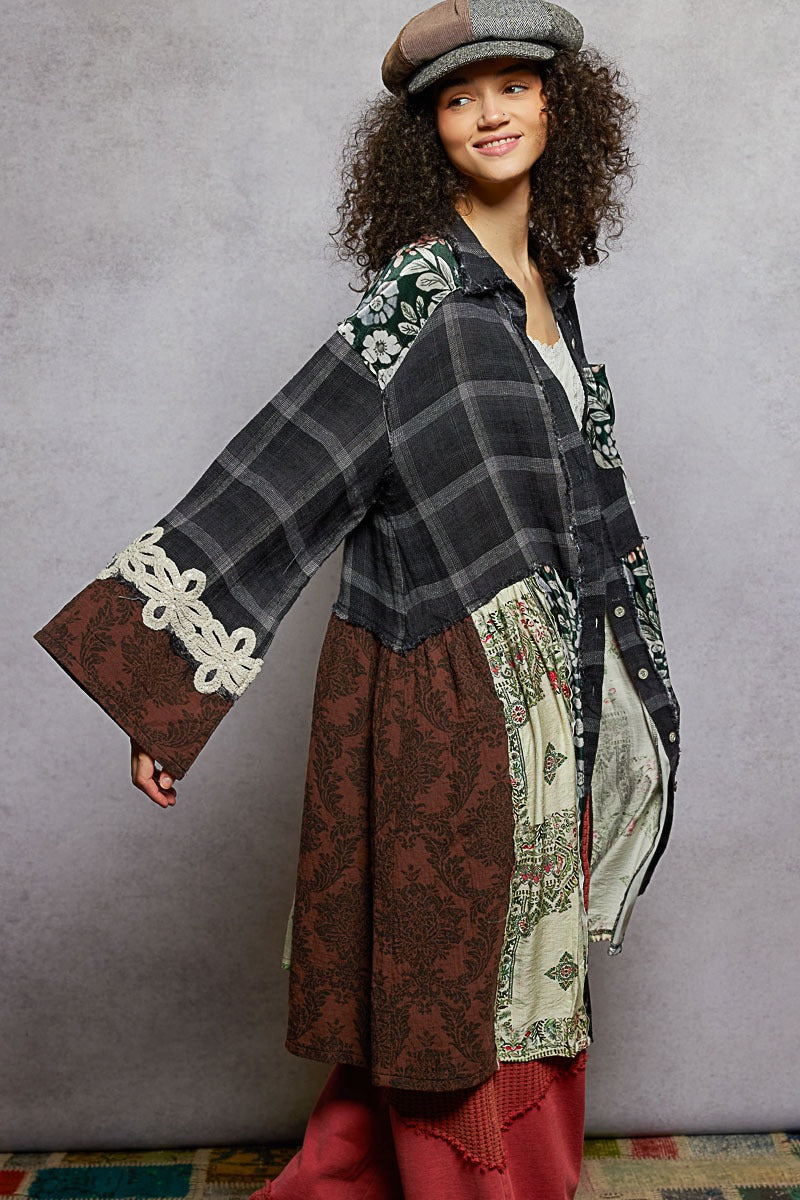 Woman wearing a plaid shirt with floral patterns and red pants against a gray background