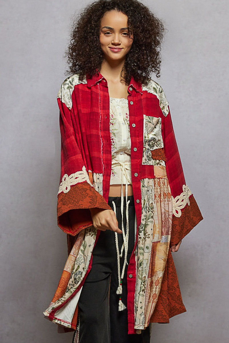 Woman wearing a red and patterned long coat against a gray background