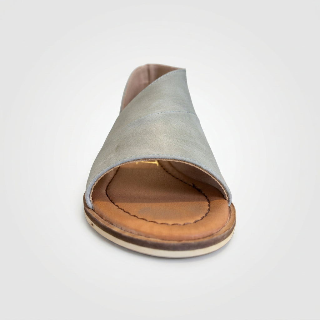 White sandal with brown sole on a glass surface