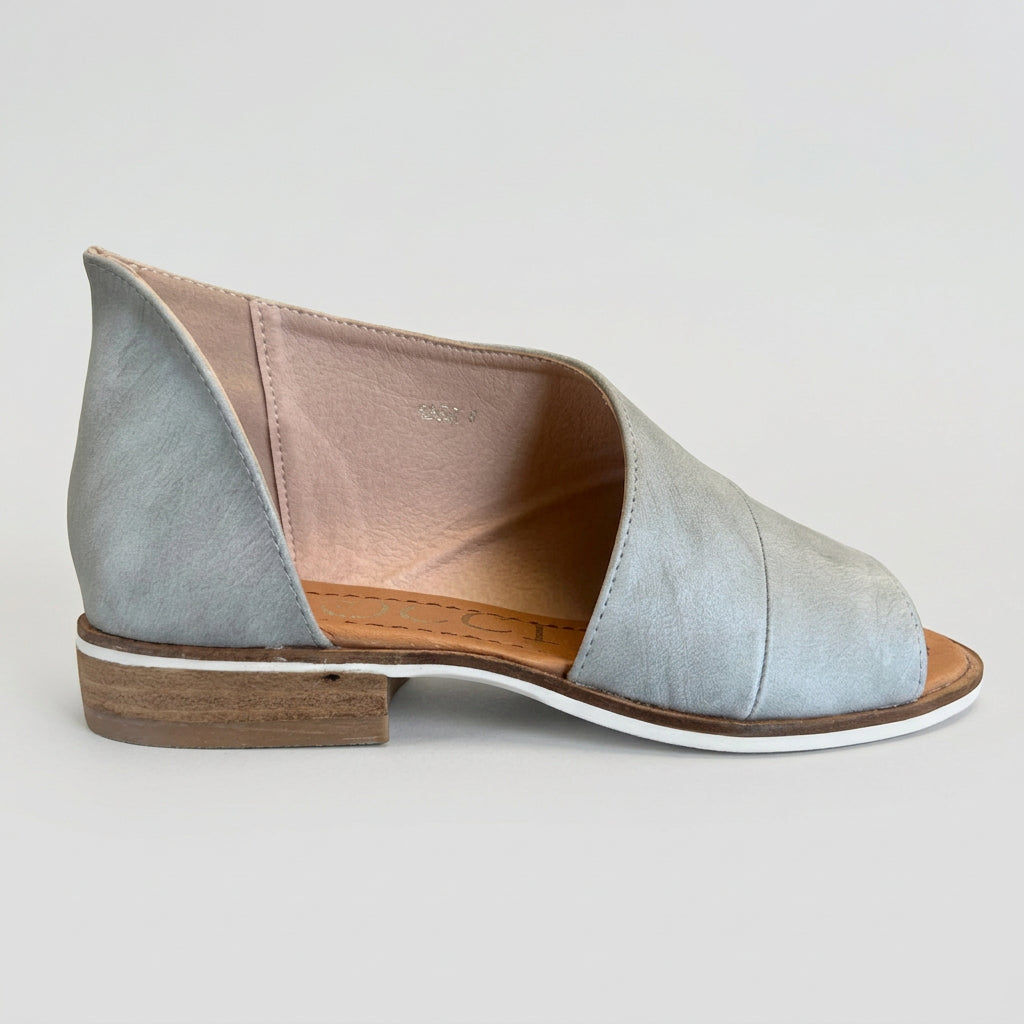 Light blue open-toe sandal with wooden sole on a reflective surface
