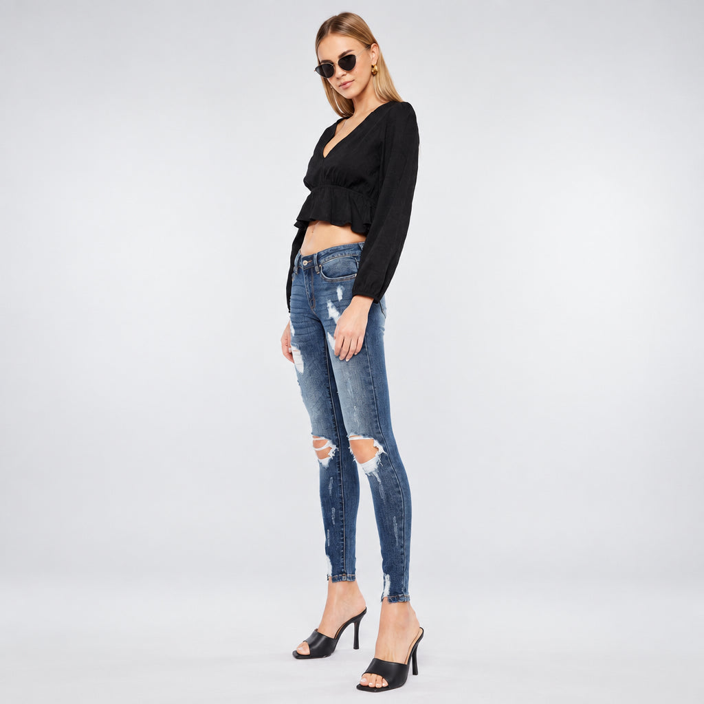 KanCan women's dark wash distressed skinny jeans in three-quarter view showing the slim leg silhouette