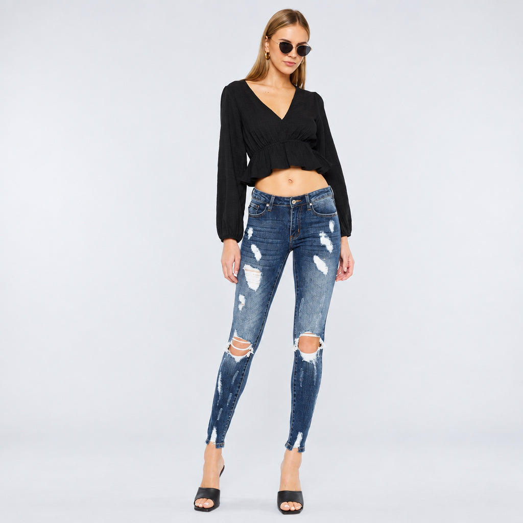KanCan women's dark wash distressed skinny jeans front view with a black cropped blouse and heels