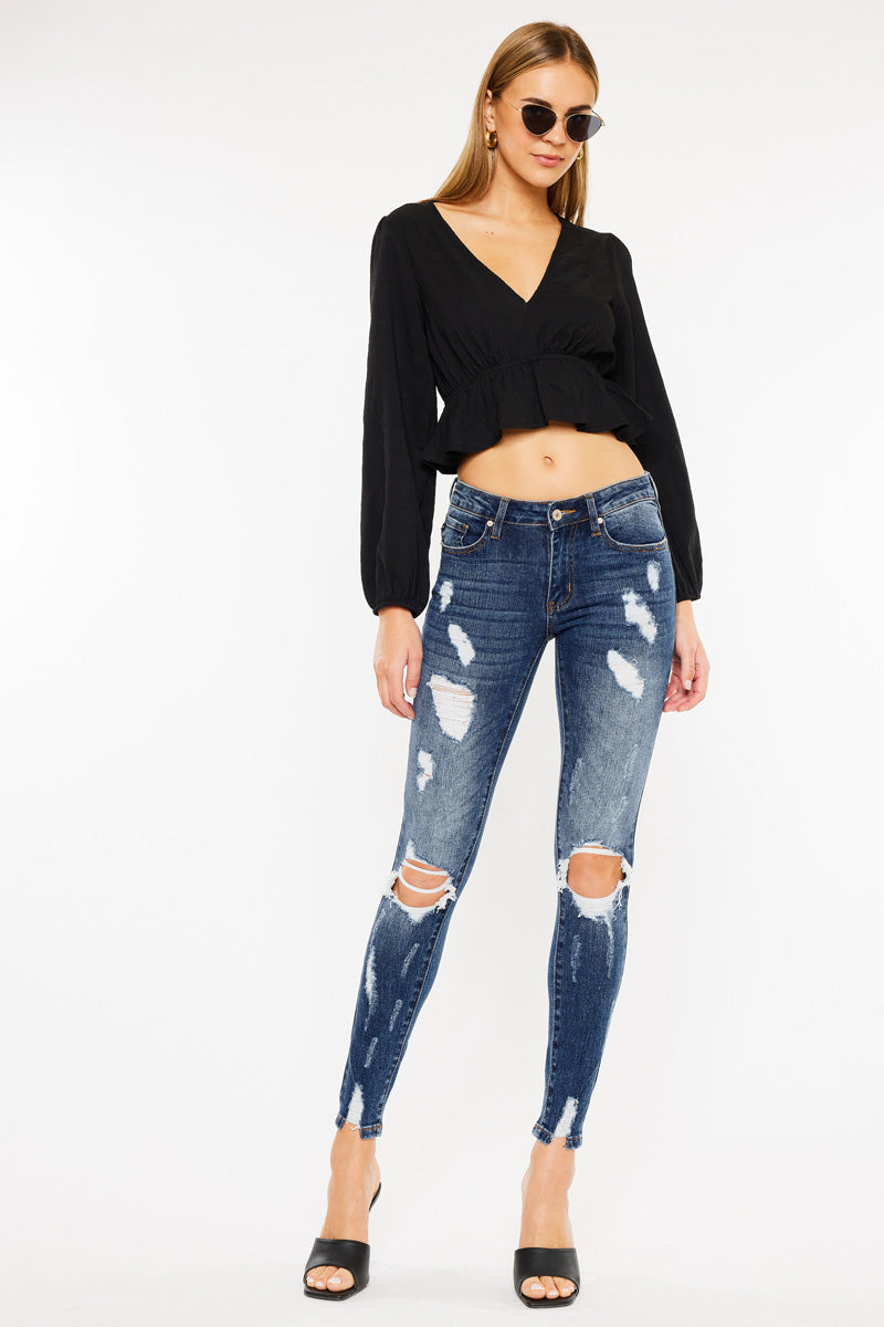 KanCan women's dark wash distressed skinny jeans front view with a black cropped blouse and heels