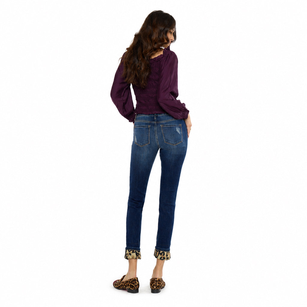KanCan women's dark wash skinny jeans showing back pockets, faded seat and leopard cuffs, rear three-quarter view