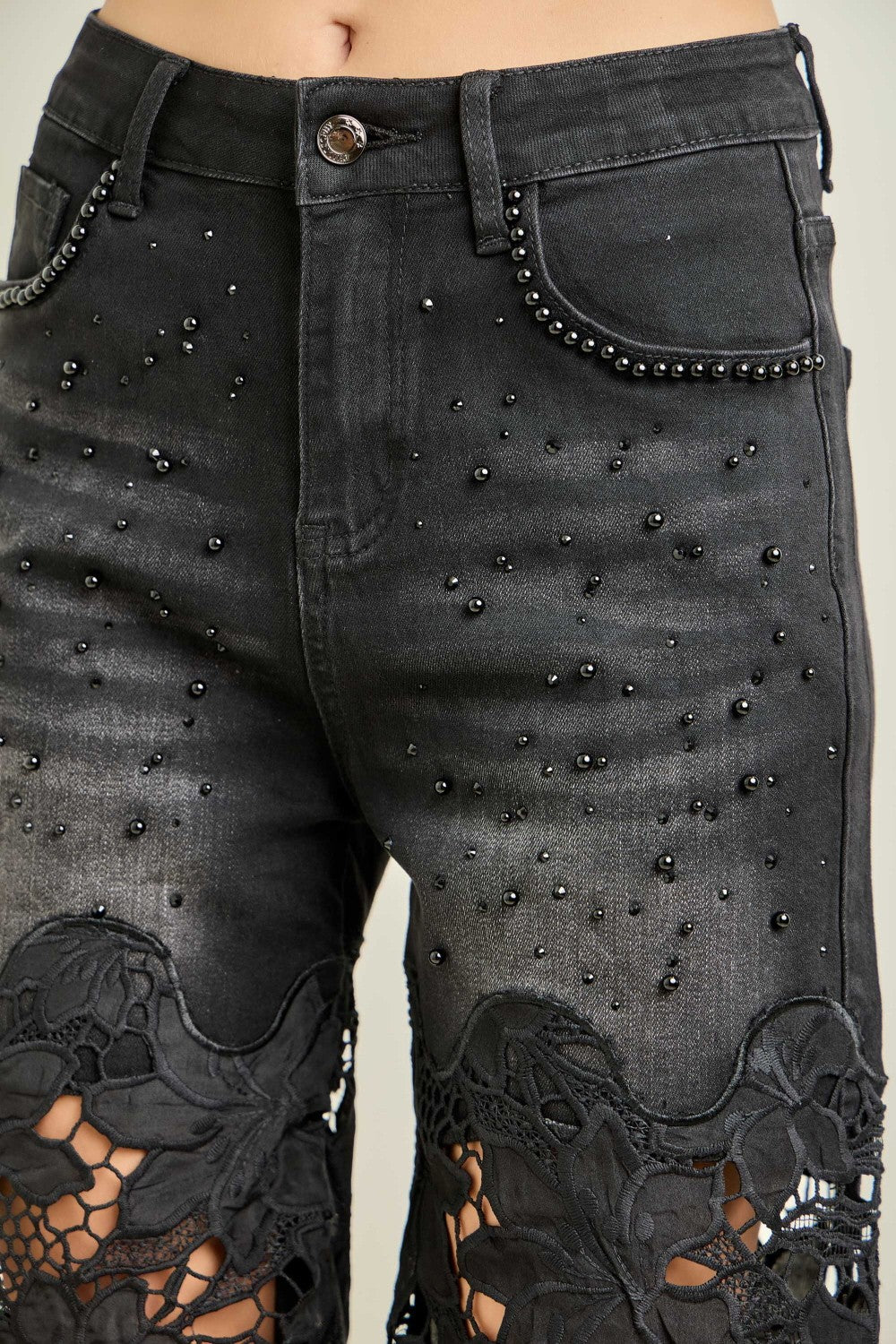 KIWI black wide-leg jeans with pearl accents and floral crochet lace panels, close-up detail view
