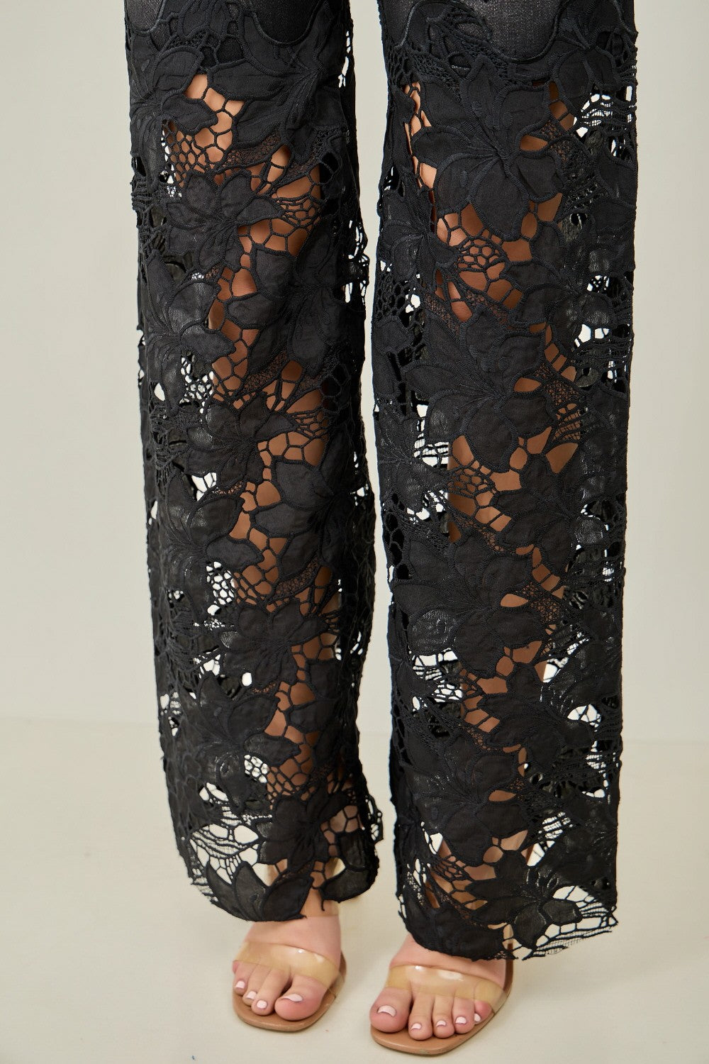 KIWI black wide-leg jeans showing floral crochet lace lower leg panels, full-length side view
