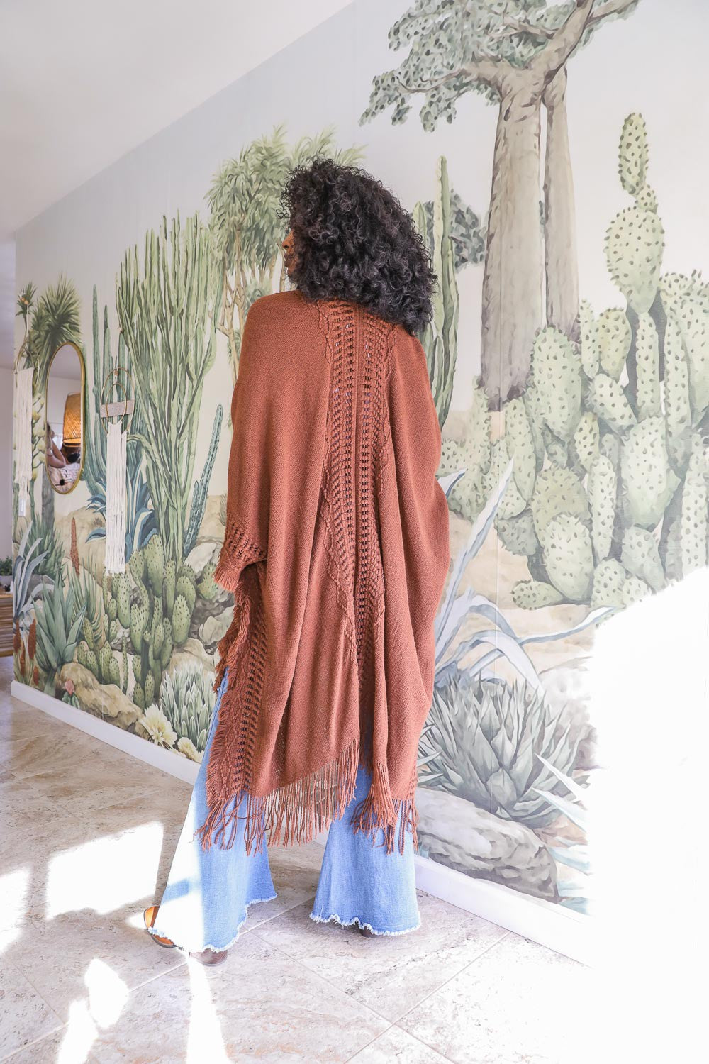 Leto Collection women's brown open-front ruana with fringe, styled with flared jeans