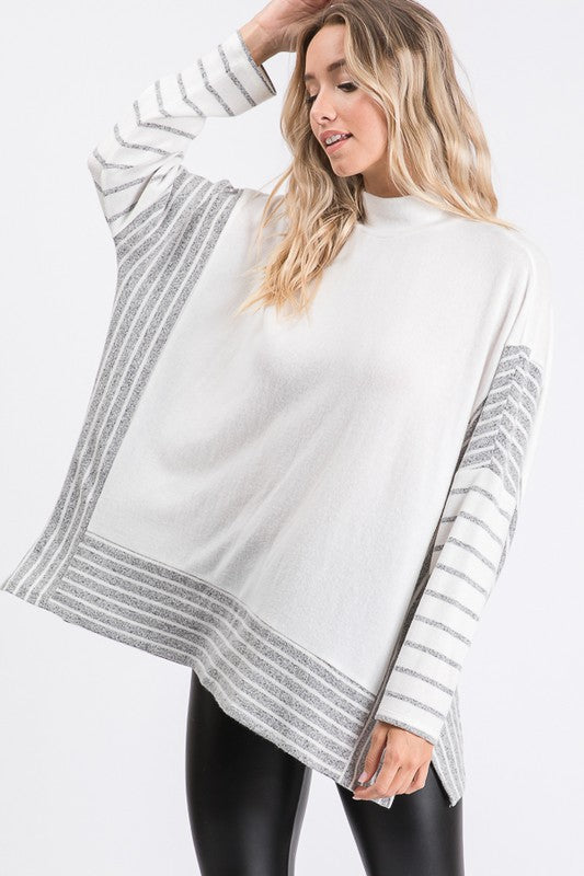 a woman wearing a white sweater and black leggings