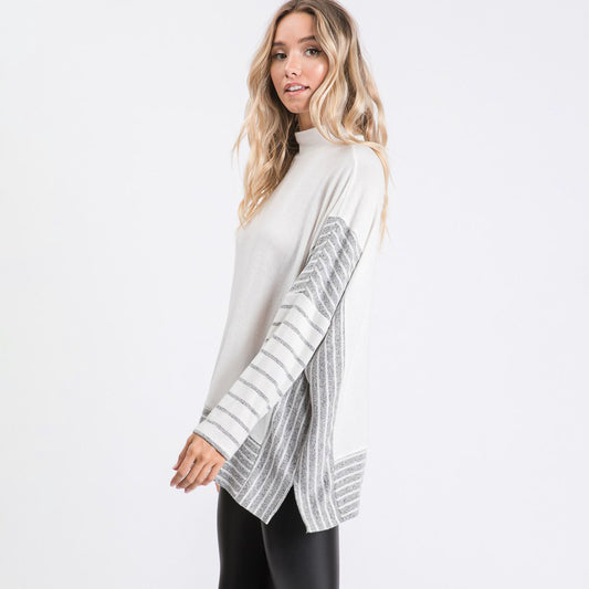 a woman wearing a white sweater and black leggings