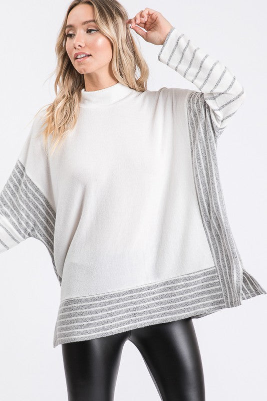 a woman wearing a white sweater and black leggings