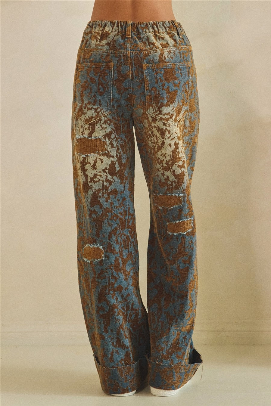 Oli & Hali brown denim distressed wide-leg pants on model, back three-quarter view showing patch accents and cuffed hem
