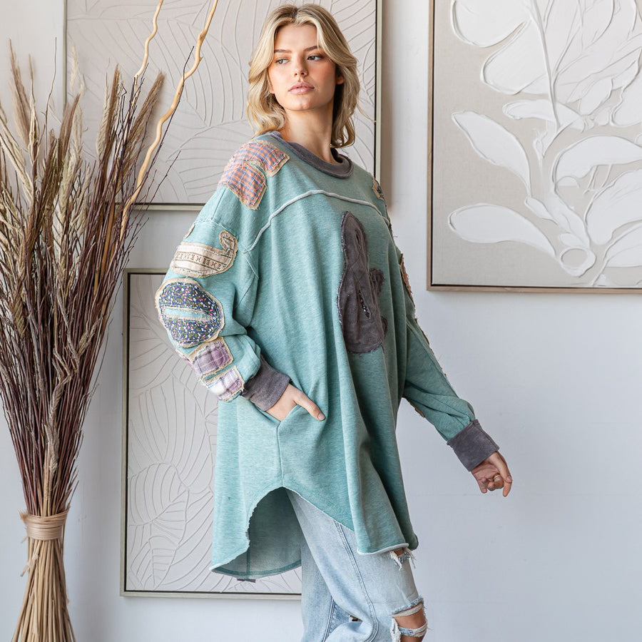 Oli & Hali sage mineral-wash pullover top, side view showing high-low hem and patchwork sleeve
