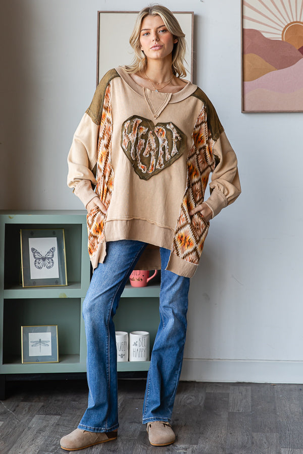 Tan heart patchwork pullover styled with blue flare jeans and taupe shoes, full outfit view