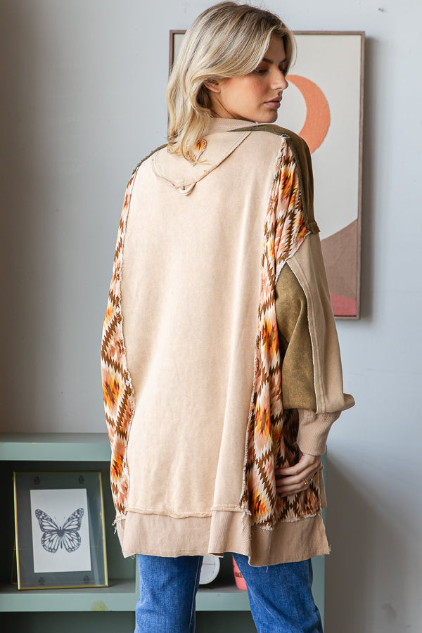 Back view of a tan pullover with geometric side panels, olive shoulders and ribbed hem