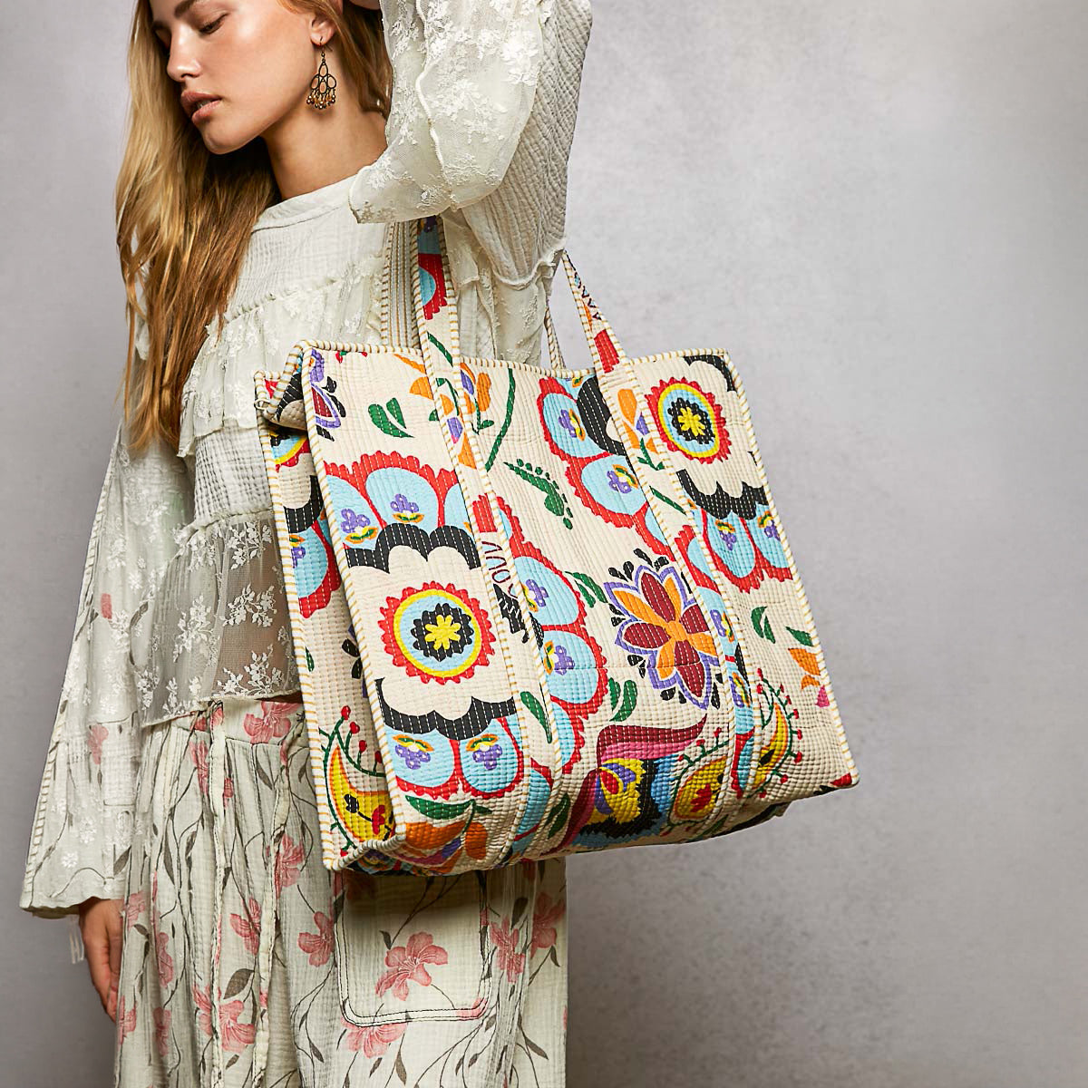 POL Clothing Cream Multi multicolor quilted tote displayed on a rustic stool
