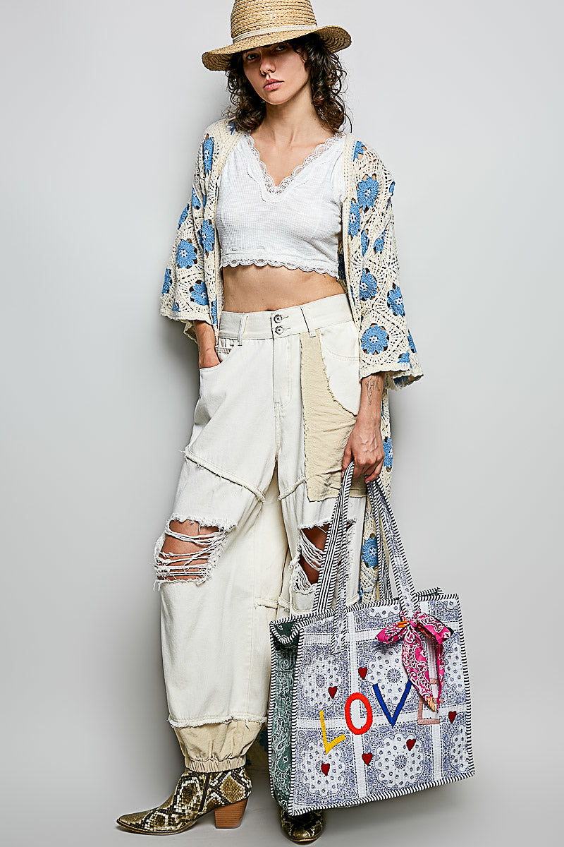 Full outfit view showing the scale of a paisley LOVE tote carried at the model's side