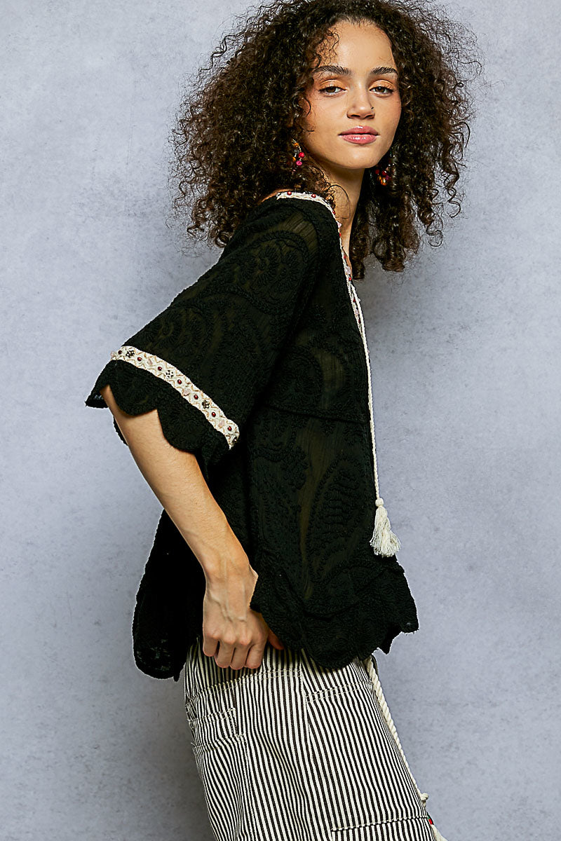 POL women's black crochet blouse on model, side view showing flared sleeve and scalloped cuff
