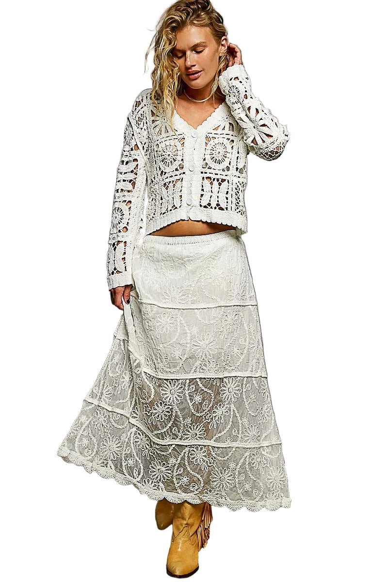 Woman wearing a white lace outfit with a gray background