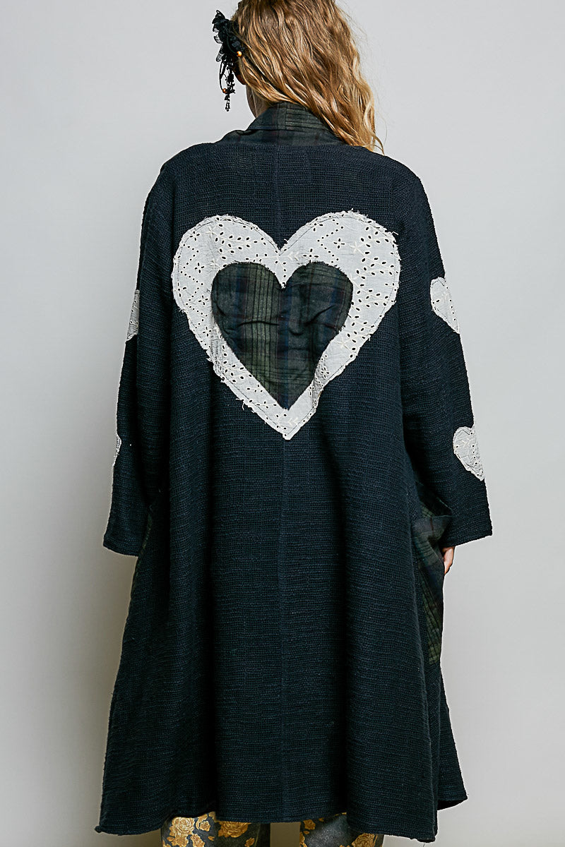 POL Clothing Natural Multi plaid patchwork longline coat, back view showing large white eyelet lace heart appliqué on model
