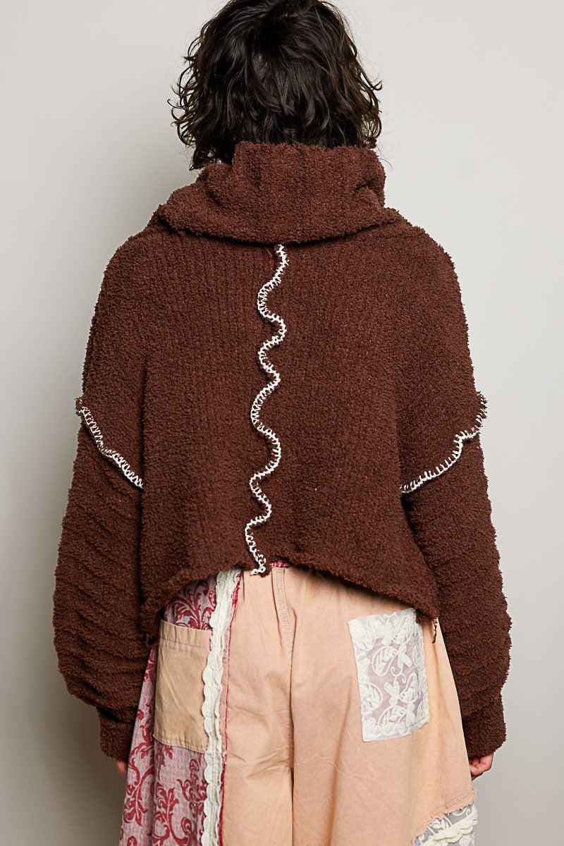 POL Clothing brown boucle turtleneck sweater with floral patch detail, close-up front view on model

