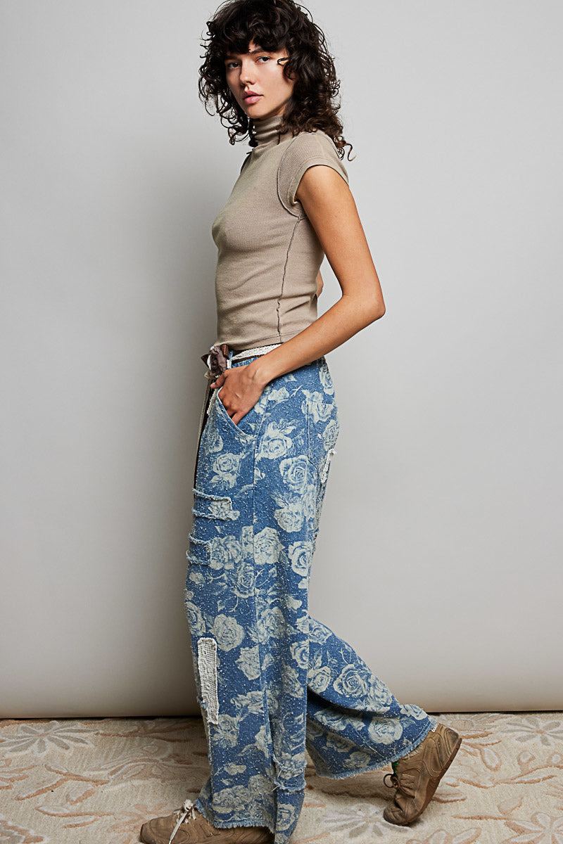POL Clothing blue rose floral wide-leg denim pants, three-quarter side view showing full length and crochet side detail on model
