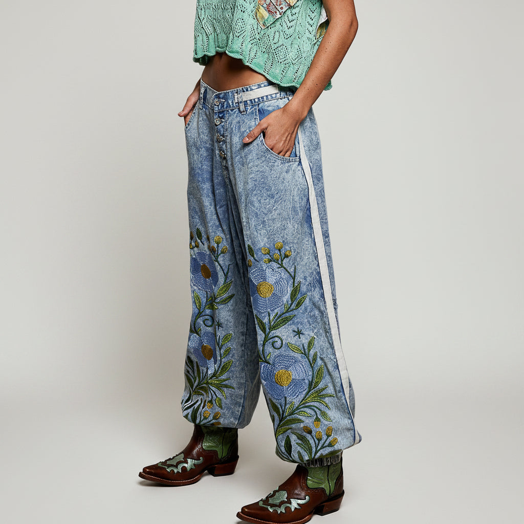 POL blue denim floral embroidered jogger pants, close-up side view showing embroidery, white side trim, and button-fly
