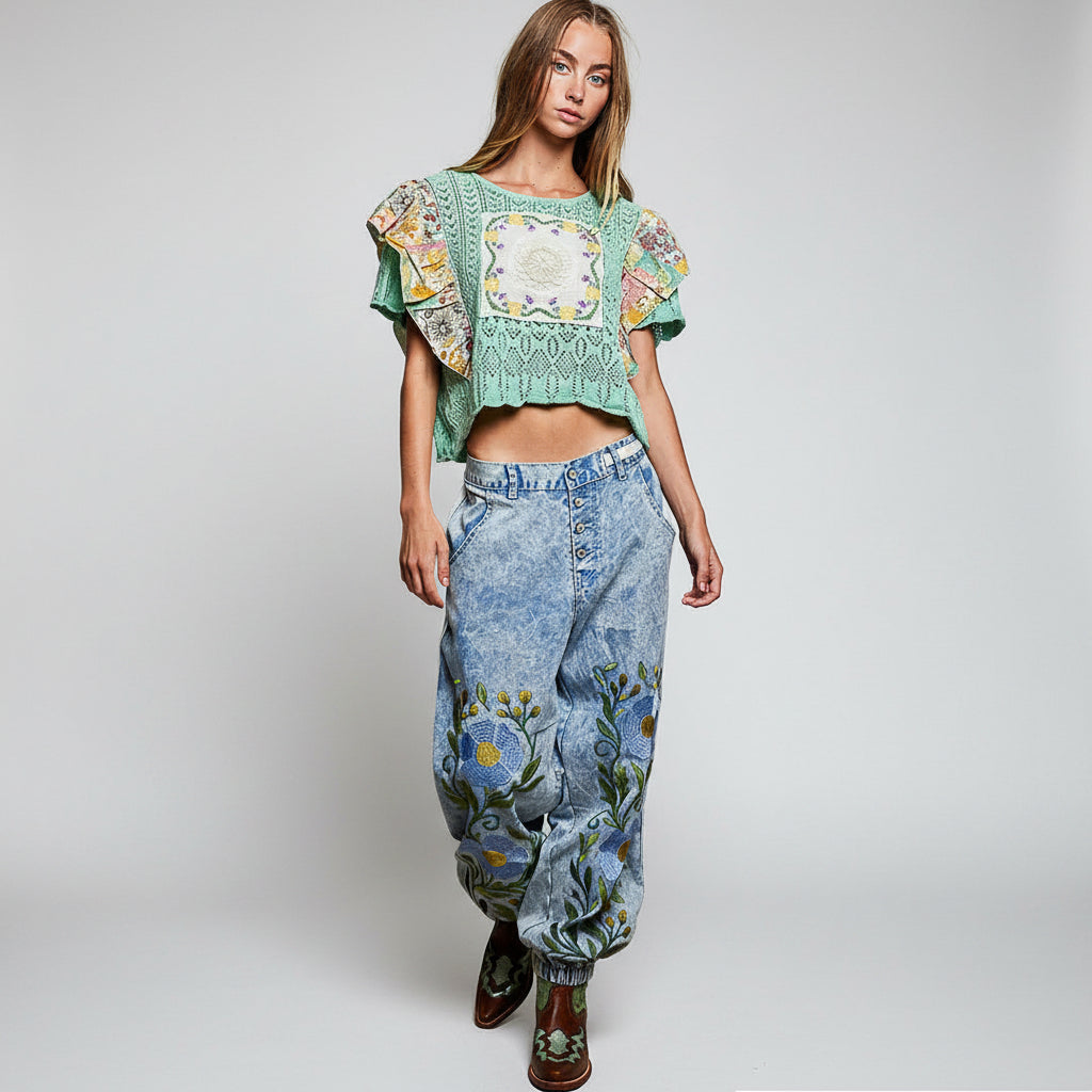 POL women's blue denim floral embroidered jogger pants, full-length side view on model with western boots
