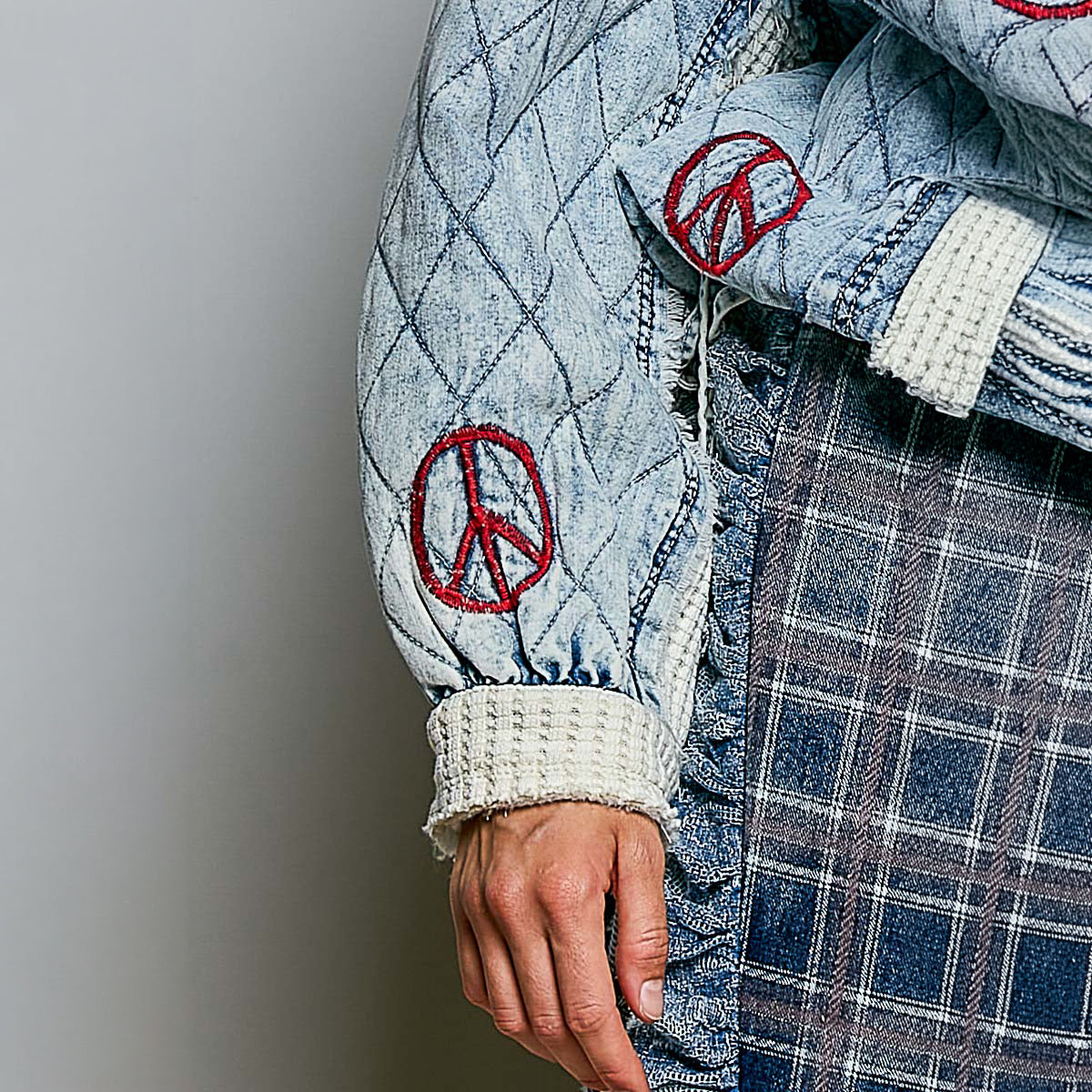 POL Clothing quilted denim sleeve detail with red peace sign embroidery and cream waffle-knit cuff, close-up side view
