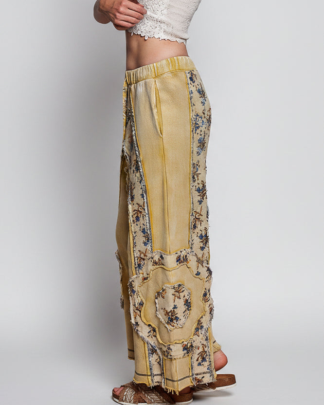 POL Clothing lemon floral patchwork wide-leg pants on model, side view showing panel detail and frayed hem
