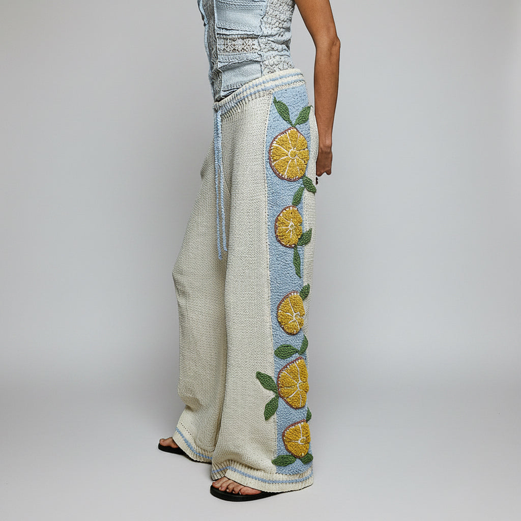 POL Clothing cream citrus embroidered wide leg knit pants with contrast side stripe on model walking outdoors