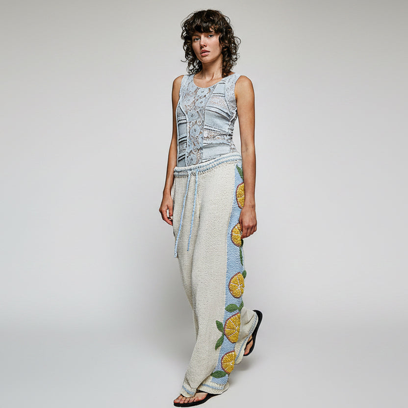 Detailed close-up of blue contrast side panel with orange citrus appliqué on POL Clothing knit pants