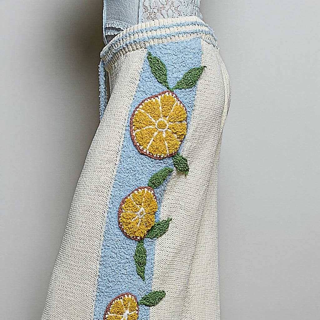 POL Clothing cream wide leg knit pants featuring ribbed drawstring waist and citrus motif details