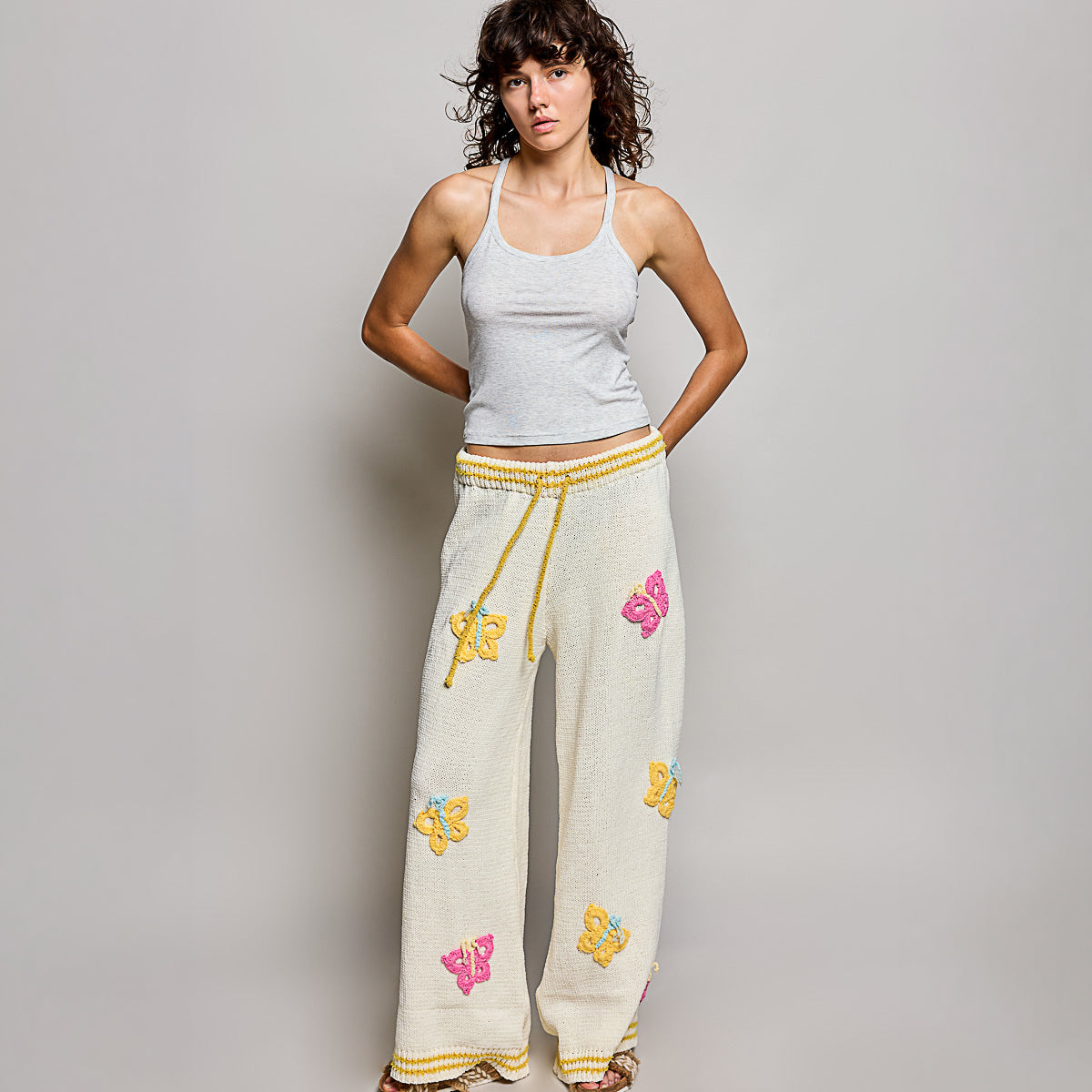 POL Clothing cream multi wide leg knit pants, full-length back view showing crochet butterfly appliques on model
